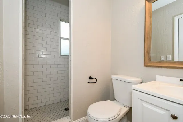 a white toilet sitting next to a shower