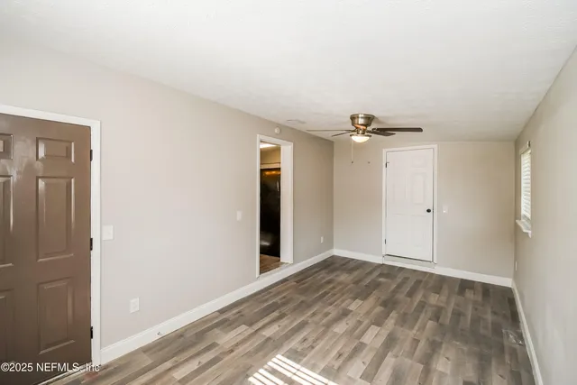 a view of a livingroom with wooden floor and a ceiling fan