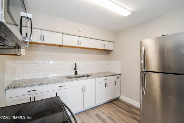 a kitchen with stainless steel appliances a refrigerator sink and cabinets