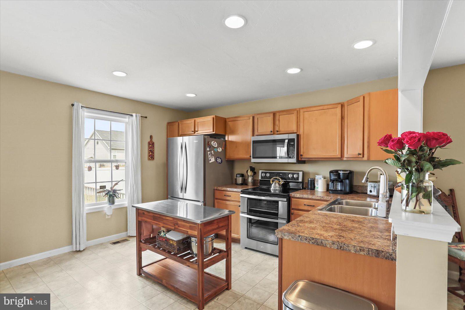14 Galaxy Drive Hanover, PA 17331 - Photo 7 of 38 a kitchen with stainless steel appliances kitchen island granite countertop a stove refrigerator and cabinets
