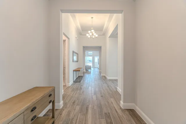a view of a hallway with wooden floor and staircase