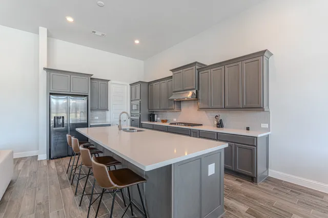 a kitchen with stainless steel appliances a sink a stove a refrigerator and cabinets