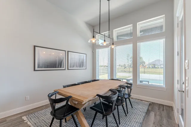 a dining room with furniture a chandelier and wooden floor