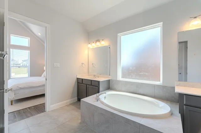 a en suite bathroom with a tub sink and mirror