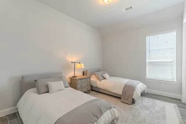 a bedroom with two beds and a window