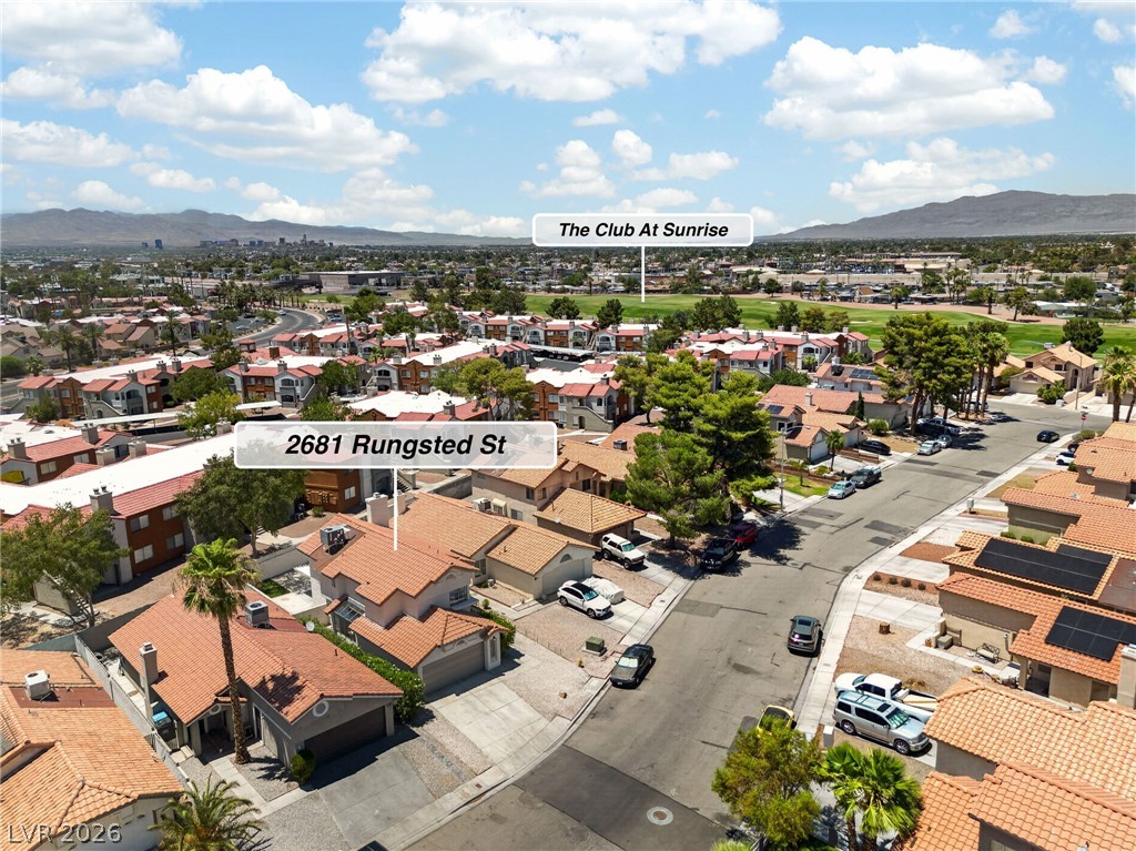 2681 Rungsted Street Las Vegas, NV 89142 - Photo 31 of 33 An aerial perspective reveals a residential neighborhood with numerous homes and streets, set against a backdrop of distant mountains.