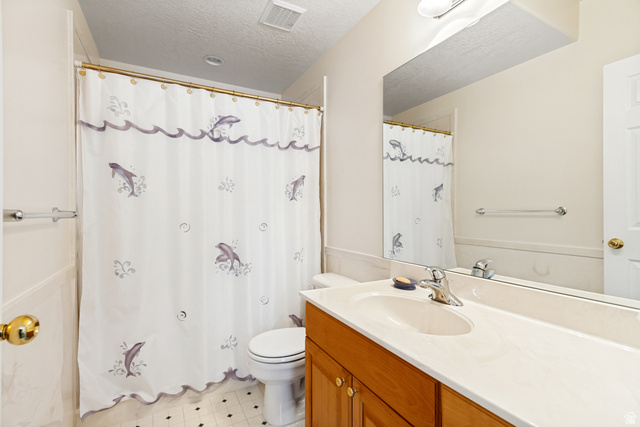 298 North Canyon Road Bountiful, UT 84010 - Photo 40 of 57 Bathroom featuring a vanity with wood-finish cabinetry, a single basin sink, a large wall mirror, and a white toilet