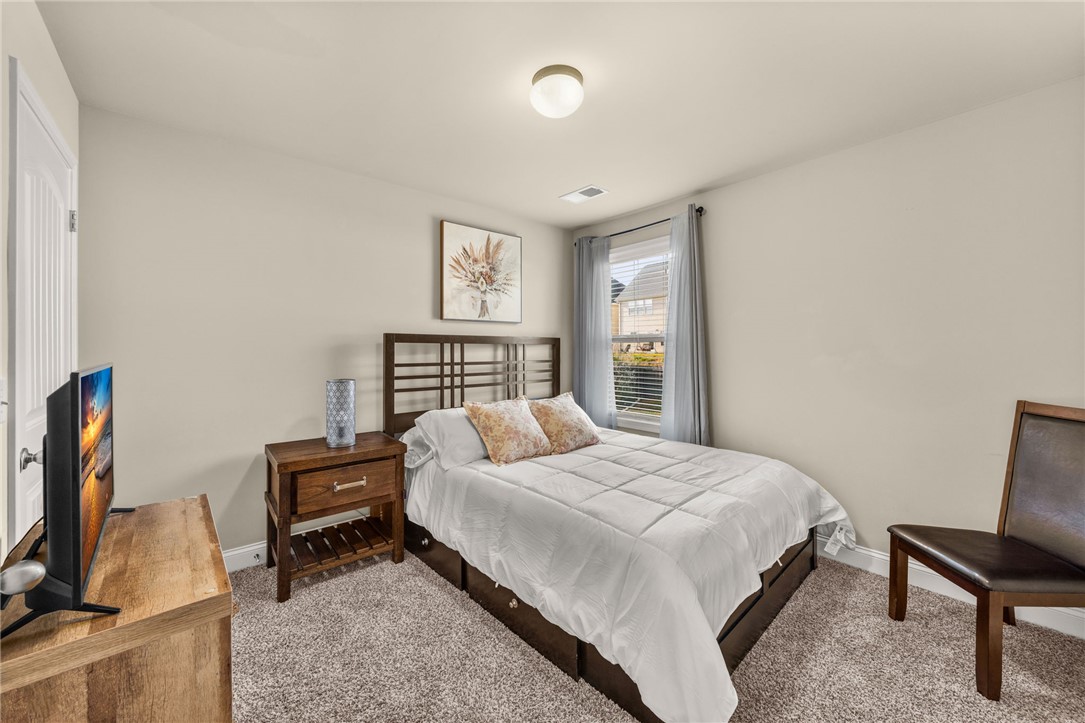 874 Wild Orchard Lane Woodruff, SC 29388 - Photo 16 of 35 This cozy bedroom features plush carpet flooring and a bright window, creating a comfortable and inviting atmosphere.