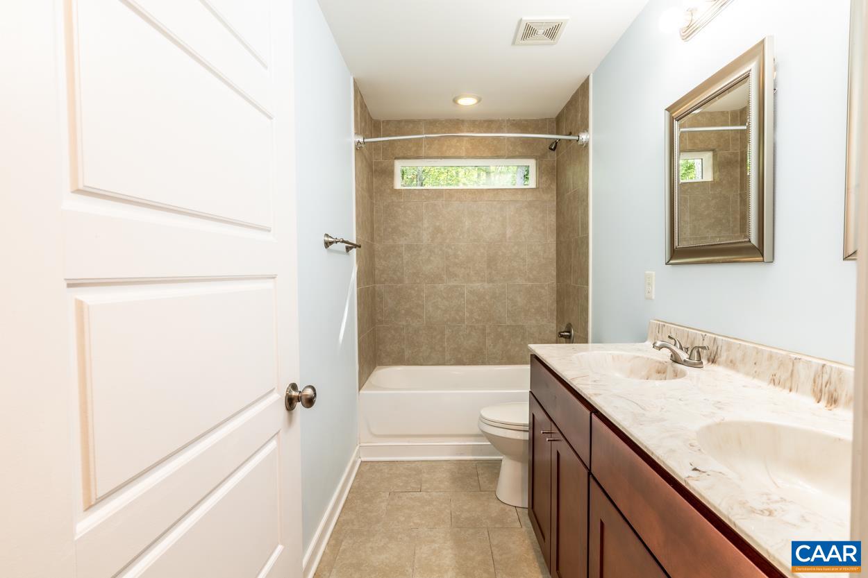 45 East Point Road Palmyra, VA 22963 - Photo 38 of 55 a bathroom with a granite countertop sink a toilet and bathtub