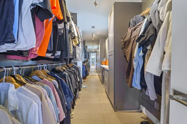 a view of walk in closet with clothes and shoes