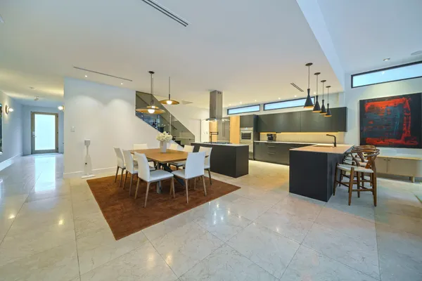 a living room with furniture a flat screen tv and kitchen view