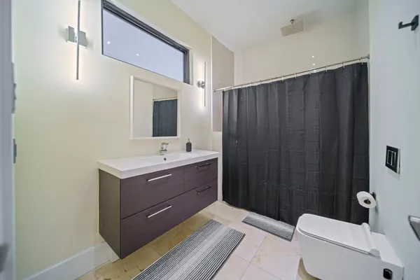 a bathroom with a toilet a sink and mirror