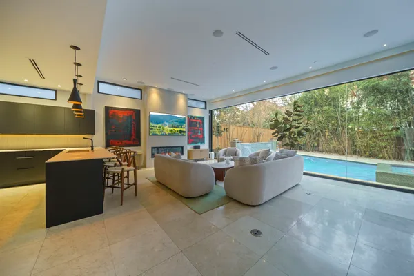 a living room with couches and kitchen view