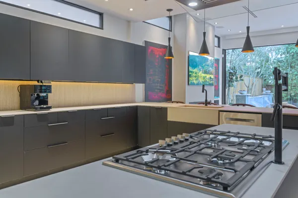 a kitchen with kitchen island granite countertop a sink stove and cabinets
