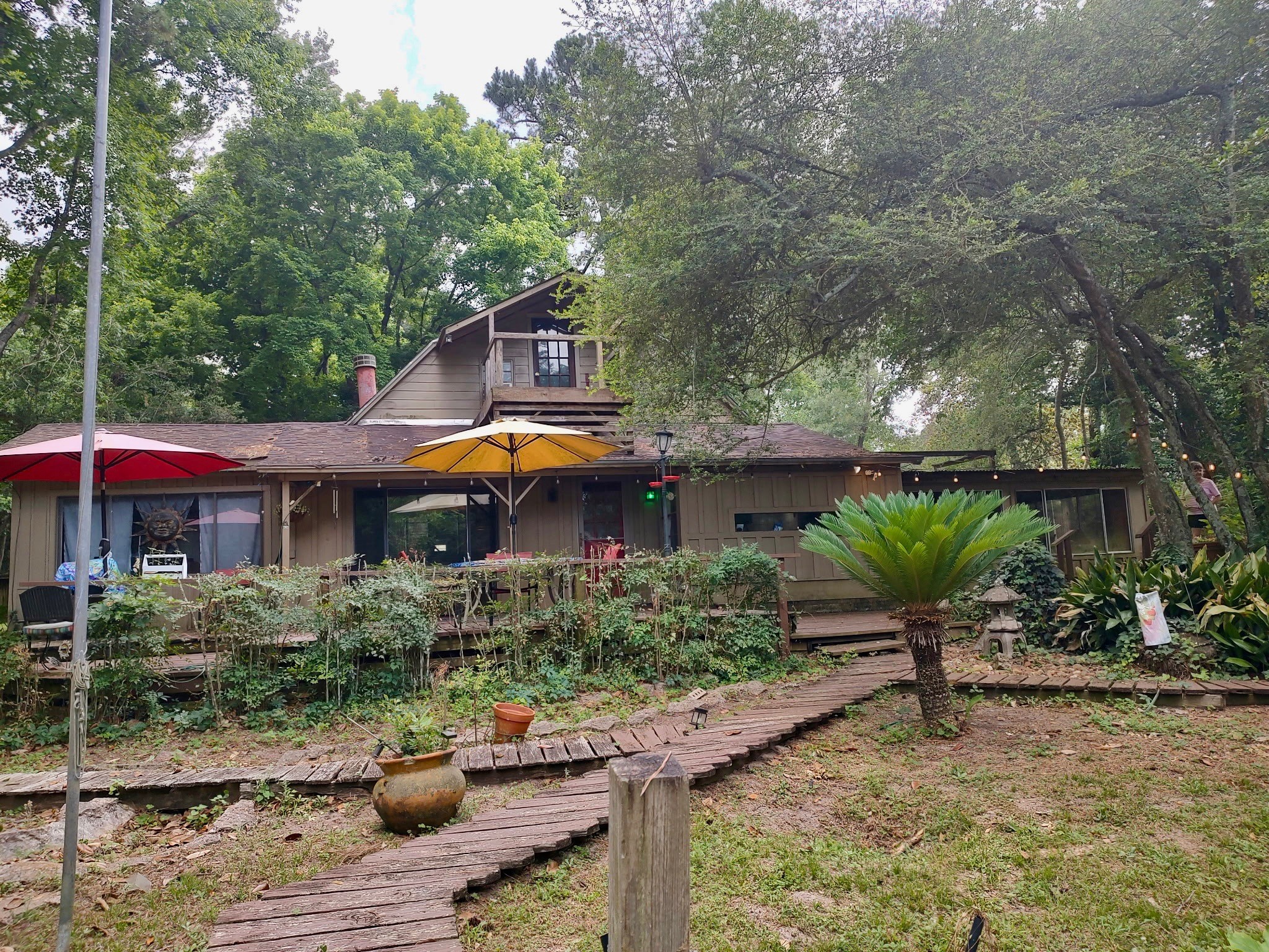 12505 Rollingwood Loop Conroe, TX 77303 - Photo 5 of 24 a backyard of a house with table and chairs under an umbrella