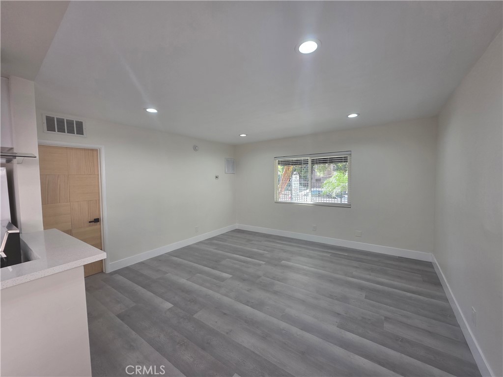 4436 Ventura Canyon Avenue Sherman Oaks, CA 91423 - Photo 3 of 13 an empty room with wooden floor and windows