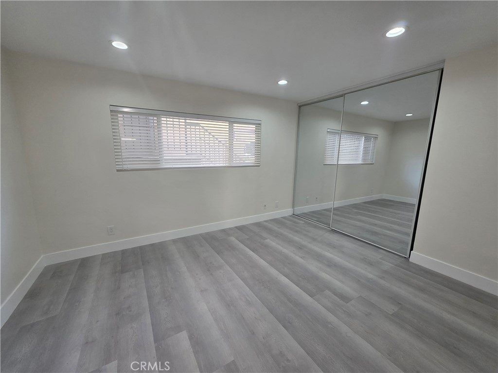4436 Ventura Canyon Avenue Sherman Oaks, CA 91423 - Photo 8 of 13 an empty room with wooden floor and windows