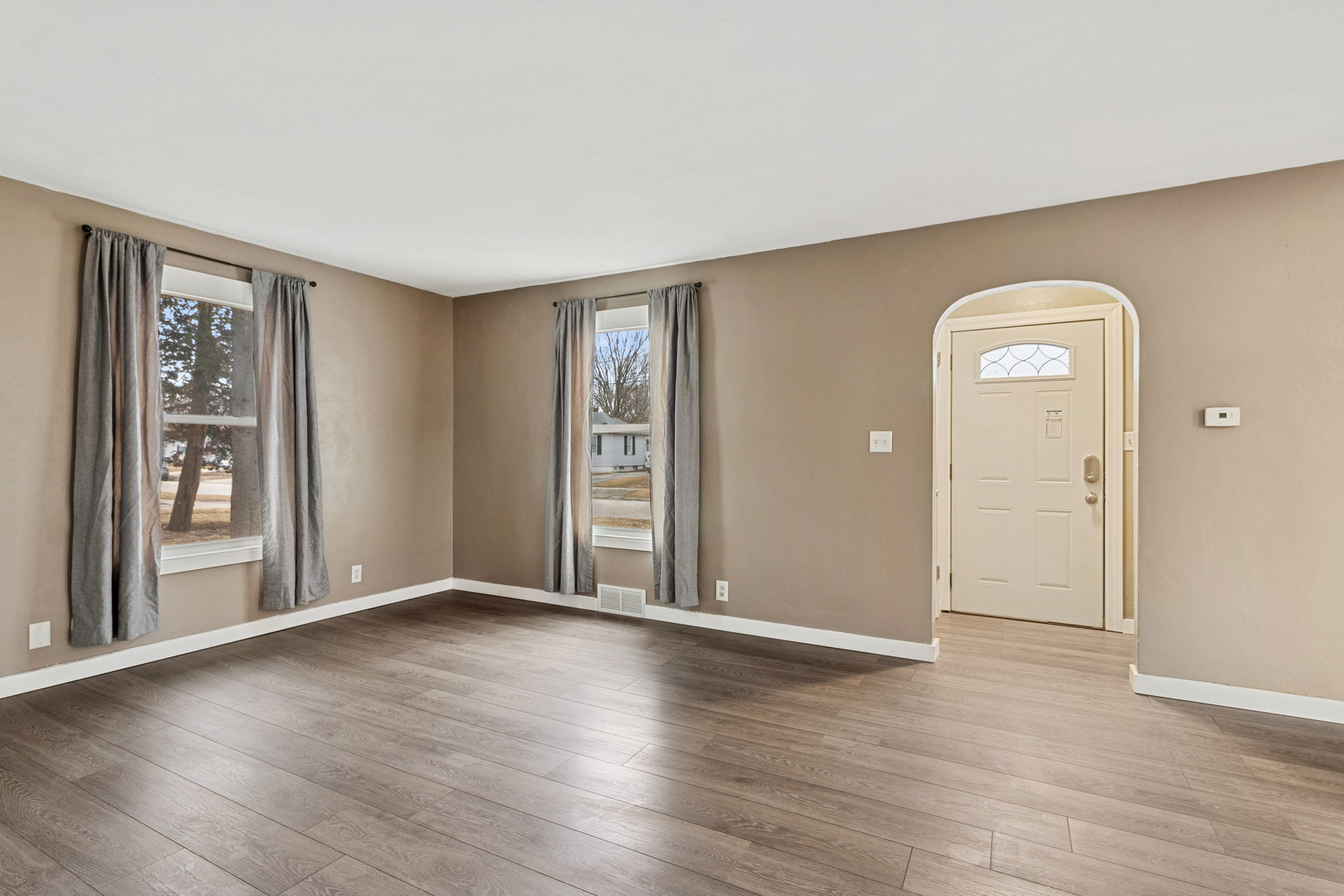 139 Elm Street DeKalb, IL 60115 - Photo 4 of 20 an empty room with wooden floor and a window