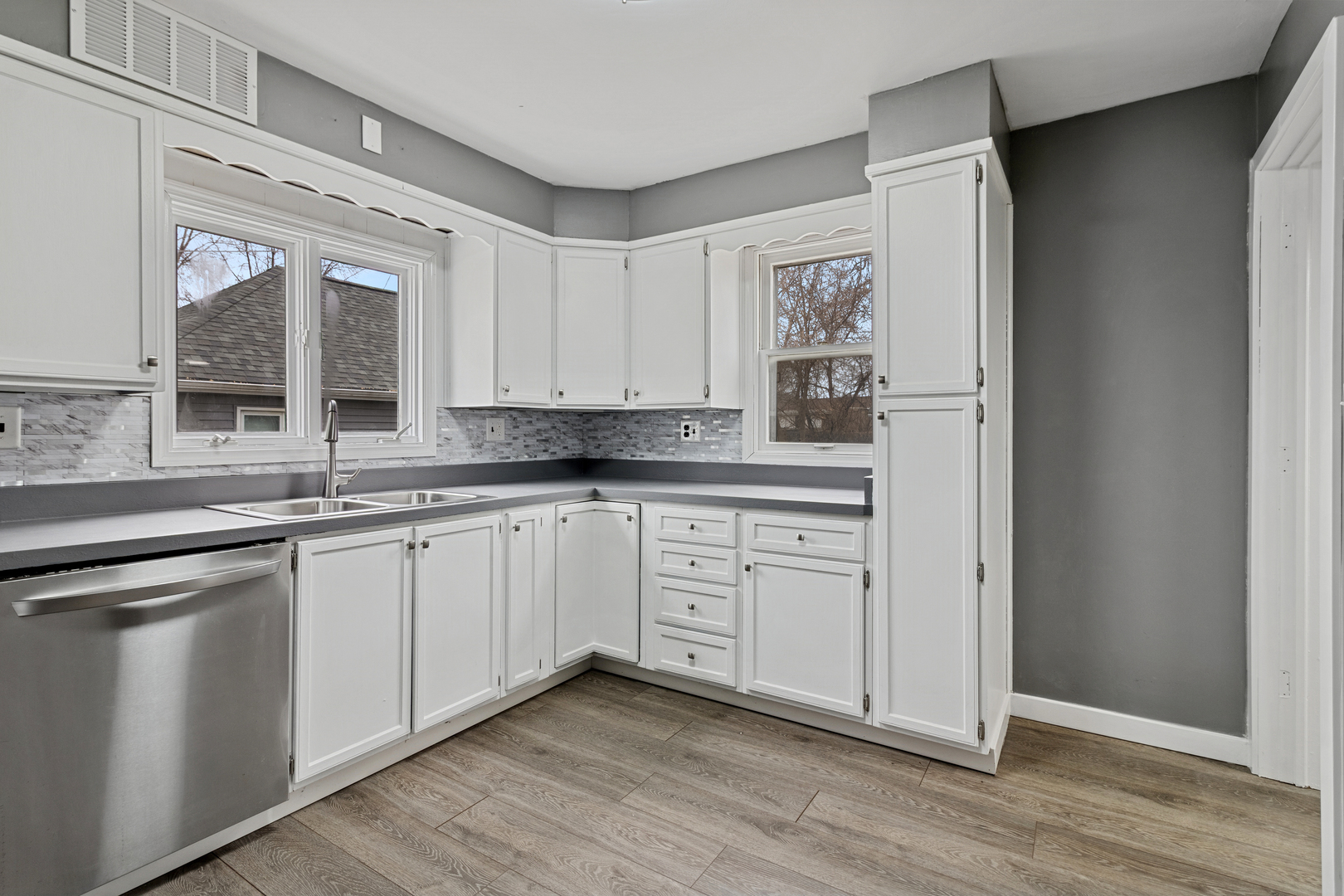 139 Elm Street DeKalb, IL 60115 - Photo 5 of 20 a kitchen with stainless steel appliances granite countertop a sink and cabinets with wooden floor
