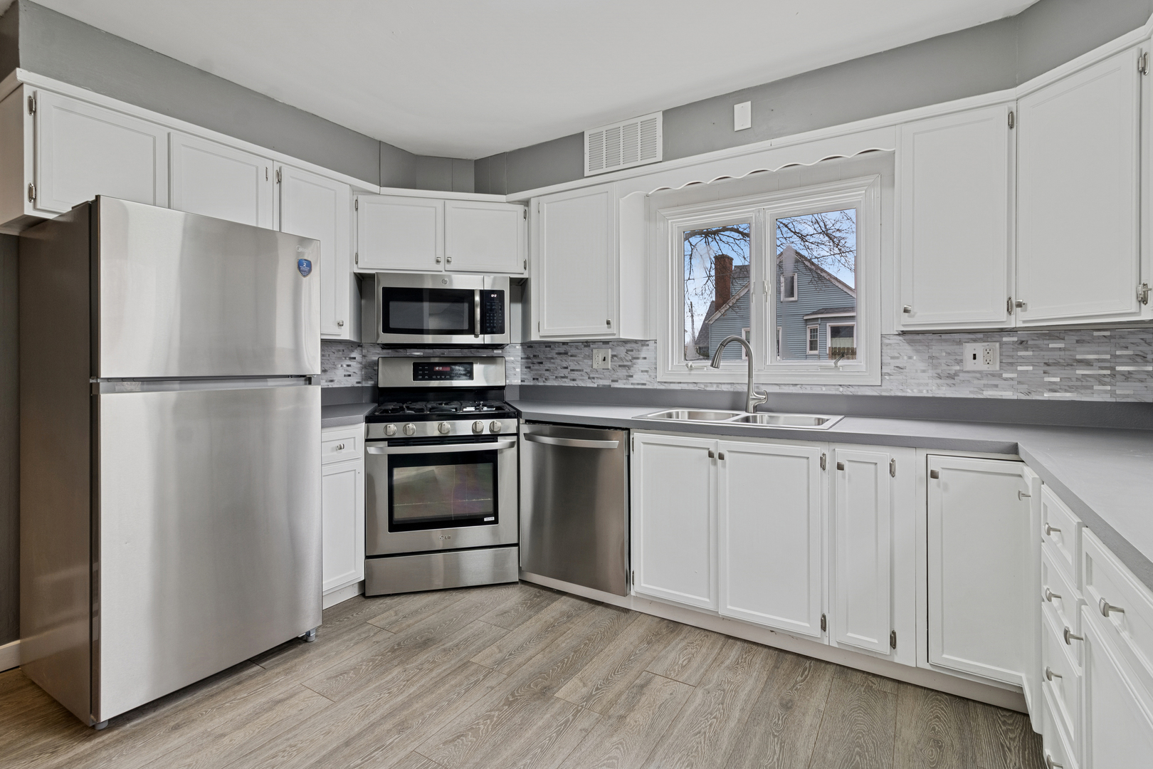 139 Elm Street DeKalb, IL 60115 - Photo 6 of 20 a kitchen with granite countertop white cabinets and stainless steel appliances