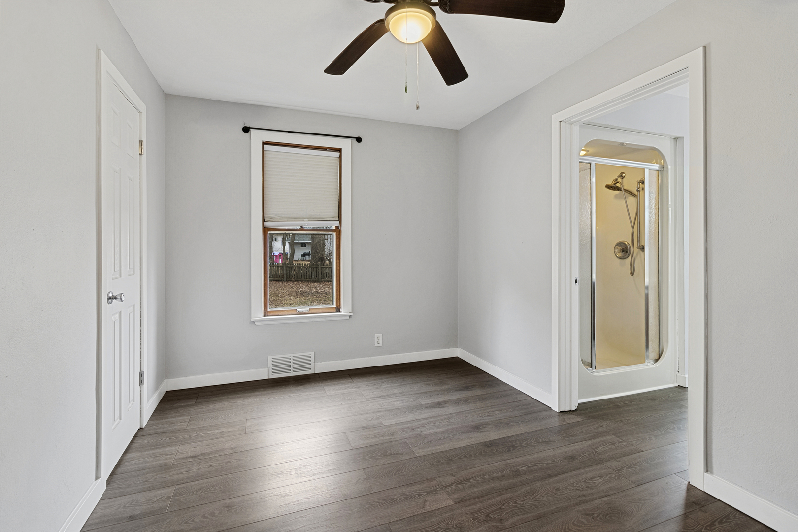 139 Elm Street DeKalb, IL 60115 - Photo 7 of 20 a view of an empty room with wooden floor and a window