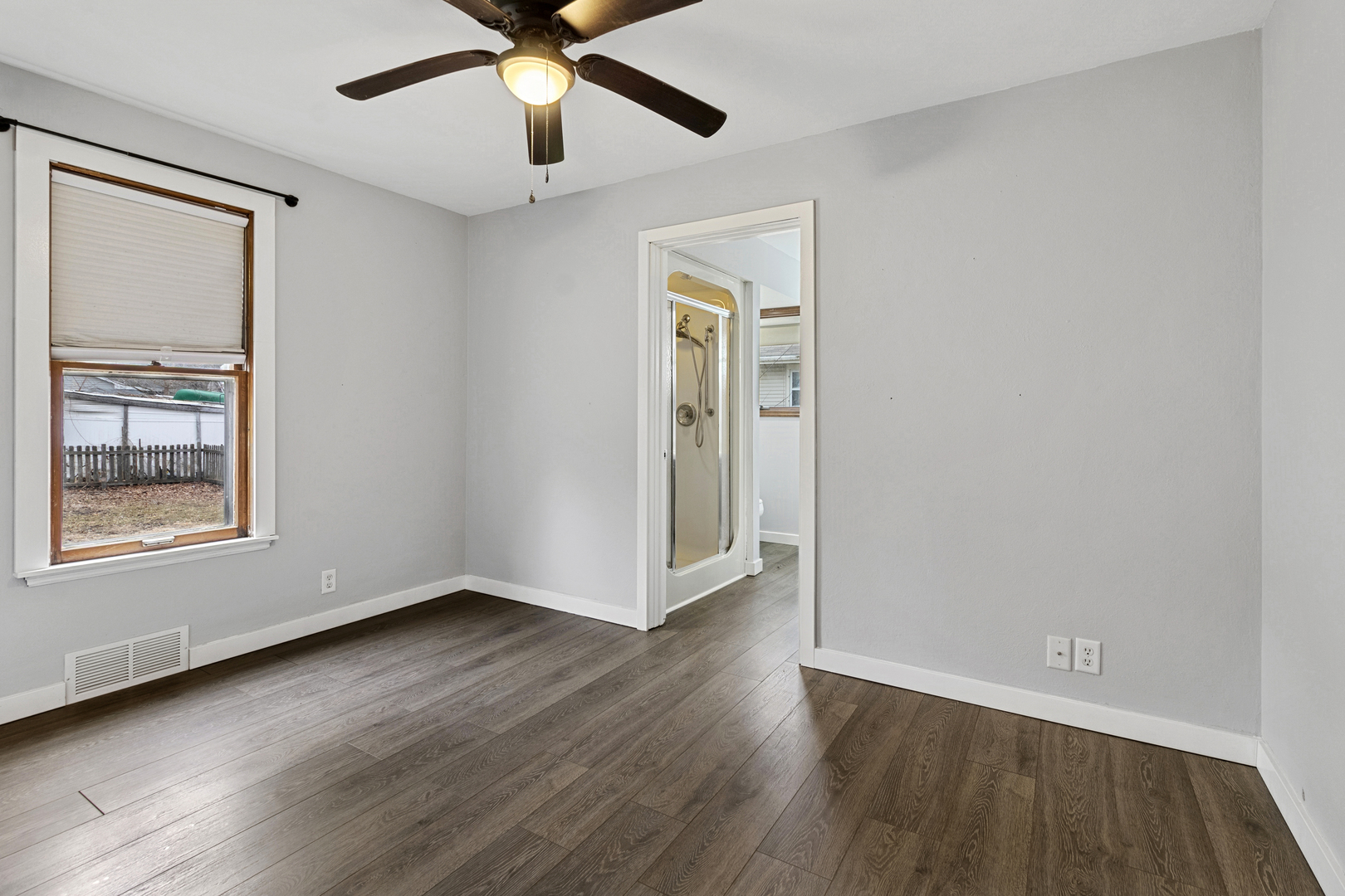 139 Elm Street DeKalb, IL 60115 - Photo 8 of 20 a view of an empty room with wooden floor and a window