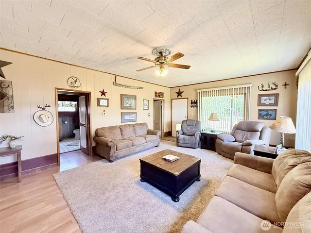 a living room with furniture ceiling fan and a rug