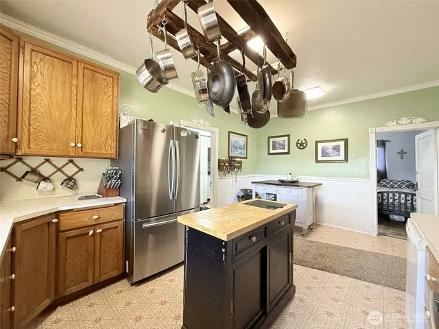 a kitchen with stainless steel appliances granite countertop a sink and a refrigerator