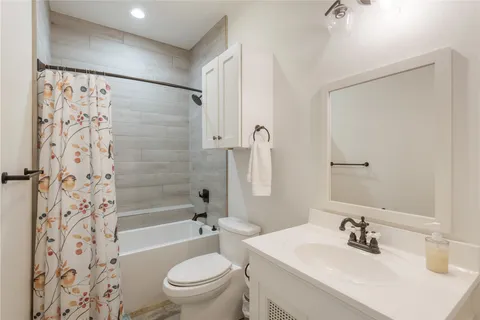 a bathroom with a sink a toilet a mirror a shower and a bathtub