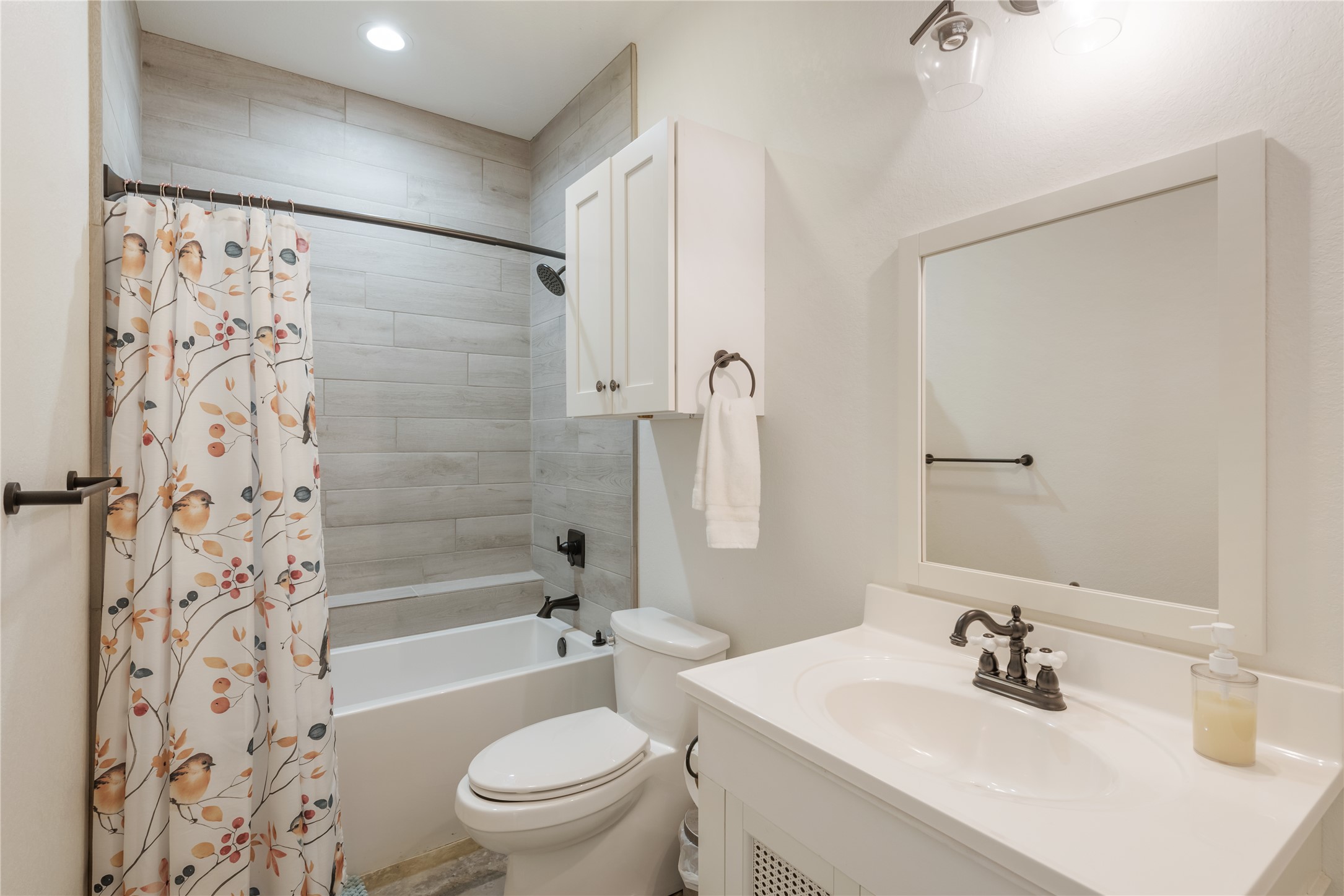 928 Bendele Road Johnson City, TX 78636 - Photo 14 of 31 a bathroom with a sink a toilet a mirror a shower and a bathtub