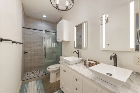 a bathroom with a sink a toilet and shower