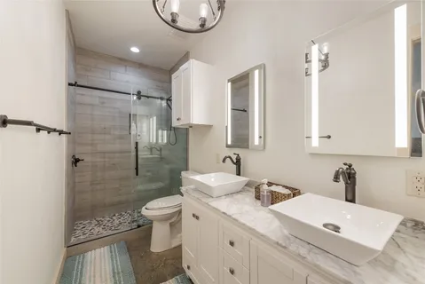 a bathroom with a sink a toilet and shower