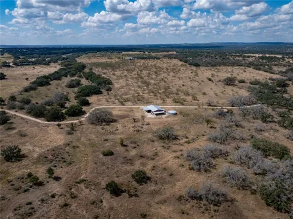 a view of a dry yard with wooden fence