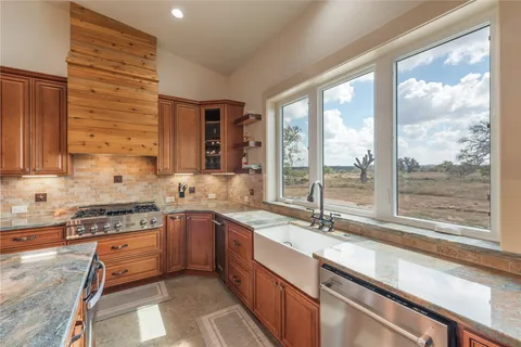 a kitchen with stainless steel appliances granite countertop a sink and a stove