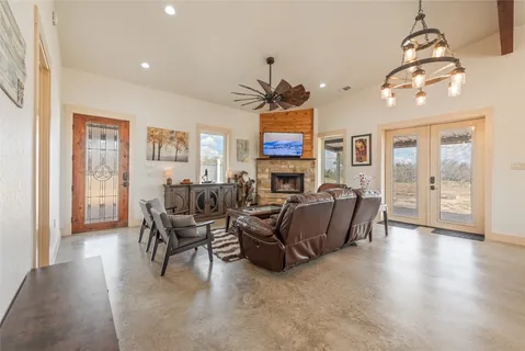 a living room with furniture a chandelier and a dining room