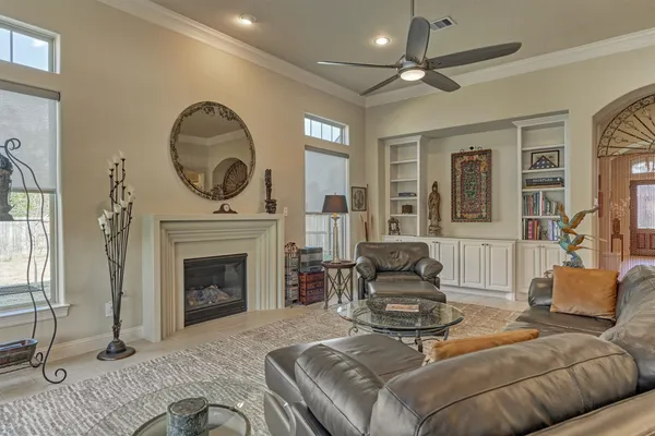 a living room with furniture a fireplace and a floor to ceiling window