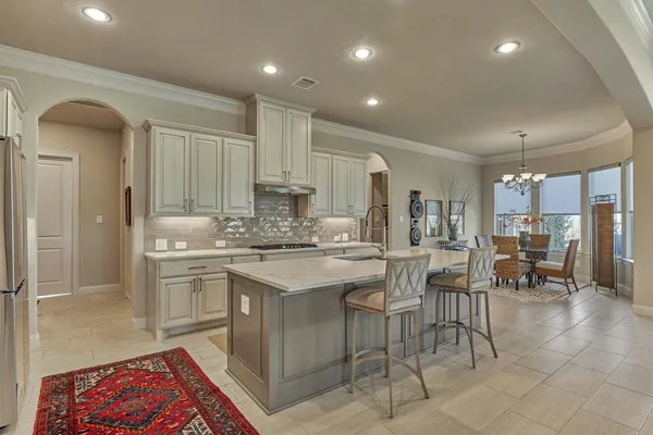 a kitchen with kitchen island granite countertop lots of white cabinets a sink and appliances