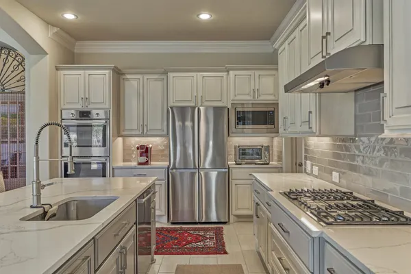 a kitchen with kitchen island granite countertop a sink stainless steel appliances and cabinets