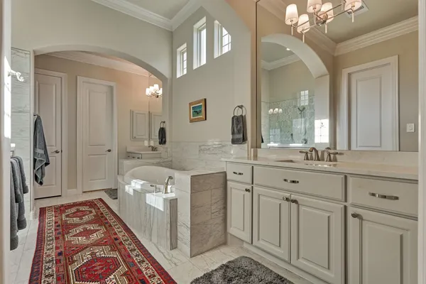 a spacious bathroom with a double vanity sink a mirror and a shower