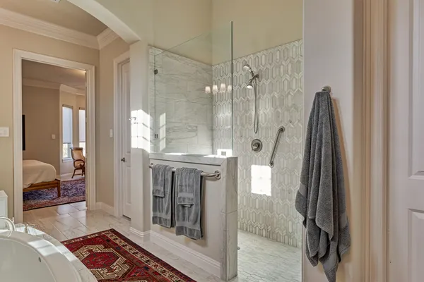 a spacious bathroom with a glass shower door and a wooden floor