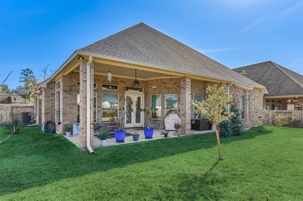 a view of a big house with a big yard and potted plants