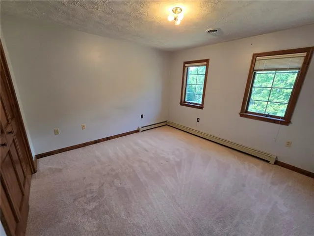 an empty room with windows and bathroom view