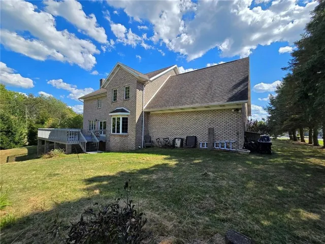 a view of a house with a big yard and a large tree