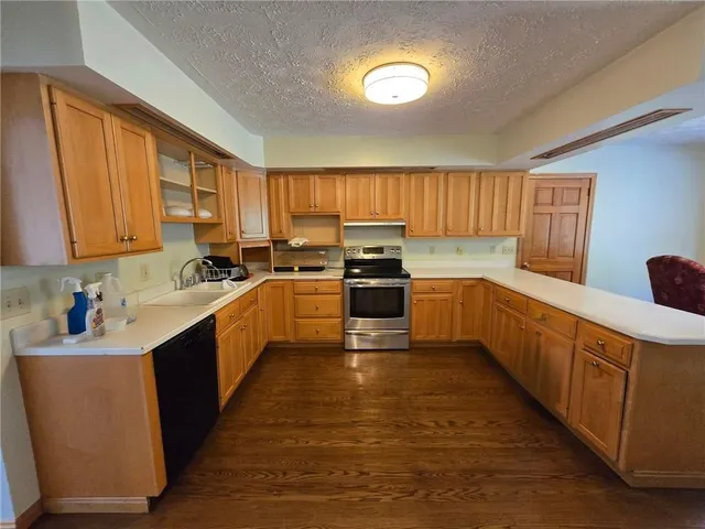 a kitchen with stainless steel appliances a sink window and cabinets