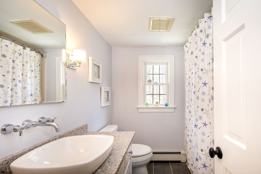 18 Longmeadow Road Scituate, MA 02066 - Photo 27 of 37 a bathroom with a sink a toilet and shower curtain