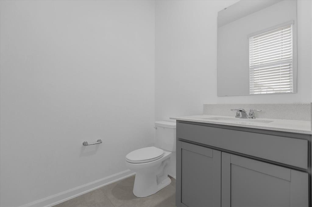 6049 Blissful Street Clermont, FL 34714 - Photo 17 of 25 a bathroom with a sink a toilet and a window