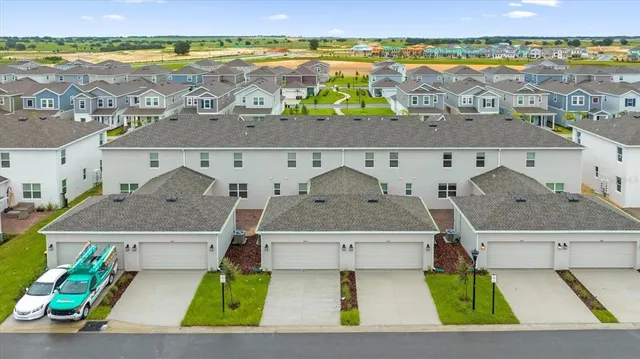 an aerial view of residential houses with outdoor space and ocean view