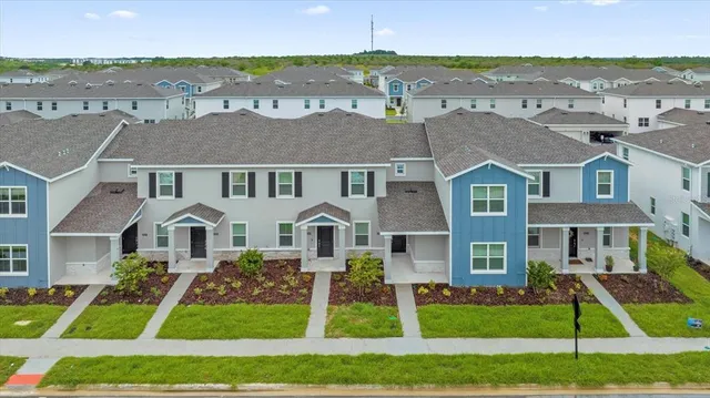 a front view of residential houses with yard and green space