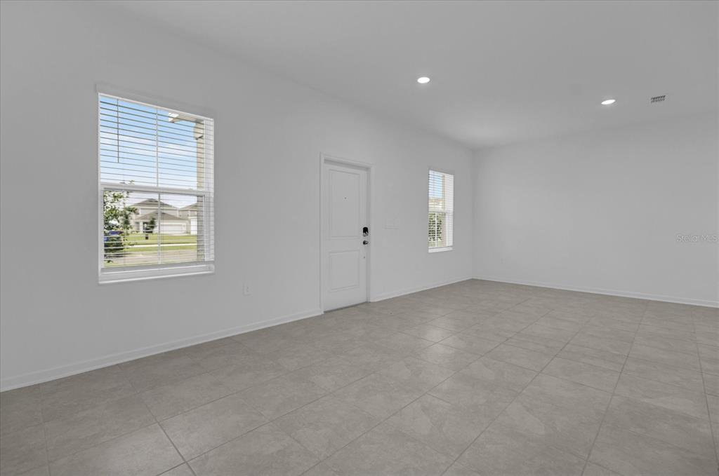 6049 Blissful Street Clermont, FL 34714 - Photo 5 of 25 an empty room with windows