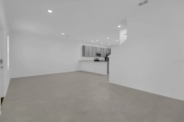 a view of an empty room with a kitchen